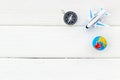 SOS Save the planet concept with the earth, plane and compass on white wooden background flat lay space for text Royalty Free Stock Photo