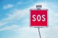 Sos sign on blue sky background. SOS sign and phone box on highway in Italy Royalty Free Stock Photo