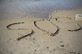 SOS - word drawn on the sand beach with the soft wave Royalty Free Stock Photo