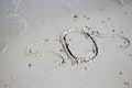 SOS - word drawn on the sand beach with the soft wave. Royalty Free Stock Photo