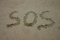 SOS written in sand Royalty Free Stock Photo