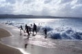 Silhouettes of children and people playing on the beach in the waves and water splashes on vacation, blue sea, waves sun light Royalty Free Stock Photo