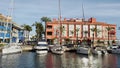 Sotogrande, Spain - 25 March 2024 A vivid scene at a marina harbor with moored boats and colorful buildings reflecting