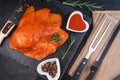 Sottilissime in a red marinade on a stone kitchen board with a branch of razmarin with spices with cutlery on a black wooden Royalty Free Stock Photo