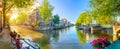 Soul of Amsterdam. Early morning in Amsterdam. Ancient houses, bridges, traditional bicycles, canals, boats, and the sun shines Royalty Free Stock Photo