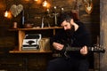 Soul music. Man bearded musician enjoy evening with bass guitar, wooden background. Man with beard holds black electric