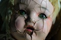 SOULlesss | Antique Baby Doll Face with Cracked Skin and Green Piercing Eyes. Royalty Free Stock Photo