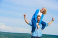 Soulmates enjoy freedom together. Man carries girlfriend on shoulders, sky background. Couple happy date having fun