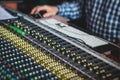 Sound editor engineer working at studio with mixing panel, mixing music and sound, stage sound mixer, boutique recording studio, Royalty Free Stock Photo