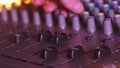 Sound Engineer Moves Faders Up and Down on Audio Mixer in Neon Light Close-Up