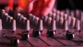 Sound Engineer Moves Faders Up and Down on Audio Mixer in Neon Light Close-Up