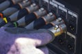 Sound engineer plugging audio cable on studio system boxes