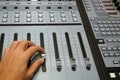 Sound engineer working on mixing console, closeup of hands doing adjust a fader Royalty Free Stock Photo