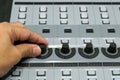 Sound engineer working on mixing console, closeup of hands doing adjust a volume knop