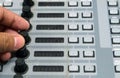 Sound engineer working on mixing console, closeup of hands doing adjust a volume knop