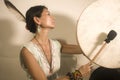 Sound healing and meditation therapy - attractive and elegant Asian Chinese healer woman playing drum at yoga studio as relaxation