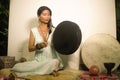 Sound healing and meditation therapy - attractive and elegant Asian Chinese healer woman playing drum at yoga studio as relaxation