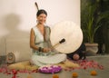 Sound healing and meditation therapy - attractive and elegant Asian Chinese healer woman playing drum at yoga studio as relaxation