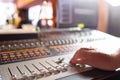 Male hand on control Fader on console. Sound recording studio mixing desk with engineer or music producer
