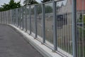 Soundproof wall of blue glass on a highway bridge embedded in metal beams, on the street. road traffic noise is reduced. safety pr