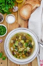 Soup with beans, mushrooms and dumplings in a bowl on a dark wooden background with herbs and garlic. Royalty Free Stock Photo