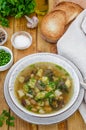Soup with beans, mushrooms and dumplings in a bowl on a dark wooden background with herbs and garlic. Royalty Free Stock Photo
