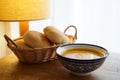 Soup and bread rolls served on wooden table with lamp Royalty Free Stock Photo