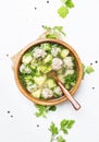 Soup with chicken meatballs, white background, top view