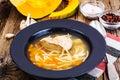 Soup with chicken, pumpkin and noodles on wooden table