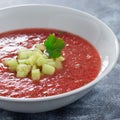 Soup Gazpacho garnished with cucumber and cilantro, in white bowl, square