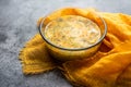 Soup kulesh with millet, potatoes and carrots in a clear bowl on an orange cloth.