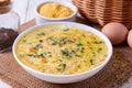 Soup kulesh with millet, potatoes and carrots in a white bowl on a wooden board background