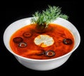 Soup with meat, olives, herbs and lemon in bowl, isolated on black background, homemade food. Royalty Free Stock Photo