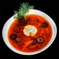 Soup with meat, olives, herbs and lemon in bowl, isolated on black background, homemade food. Royalty Free Stock Photo
