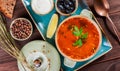 Soup with meat, olives, herbs, lemon, sour cream in bowl, black bread and spices on dark wooden background, homemade food. Royalty Free Stock Photo