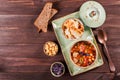 Soup with meat, oregano, chickpeas, peppers and vegetables served with crackers and bread on plate on dark wooden background Royalty Free Stock Photo