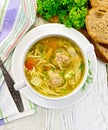 Soup with meatballs and noodles in bowl on board top Royalty Free Stock Photo