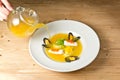 Soup with mussels and spring rolls with caviar. On a white plate. On a rustic wooden background