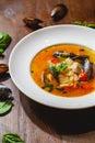 Soup with mussels and vegetables in white plate on wooden table Royalty Free Stock Photo