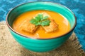 Soup of pumpkin puree and small croutons on a blue background. Close-up. Concept of the autumn menu. Royalty Free Stock Photo