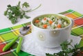 Soup with rice, green peas and carrots