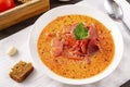 Soup, Russian borscht with sour cream and parsley in a white plate, garlic, spoon, bread, on a white towel on a brown wooden Royalty Free Stock Photo