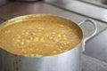 Soup in saucepan. Large container with pea soup in kitchen. Stainless steel cookware. Steel tank with food in dining room Royalty Free Stock Photo