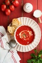 Soup. Tomato cream soup or gazpacho with herbs, seasonings, cherry tomato and parsley in white bowl on old red wooden background. Royalty Free Stock Photo