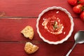 Soup. Tomato cream soup or gazpacho with herbs, seasonings, cherry tomato and parsley in white bowl on old red wooden background. Royalty Free Stock Photo