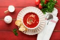 Soup. Tomato cream soup or gazpacho with herbs, seasonings, cherry tomato and parsley in white bowl on old red wooden background. Royalty Free Stock Photo