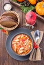 Soup with turkey, pasta, carrot, celery, tomato and cannellini beans, garnished with parmesan cheese, on the table with autumn