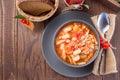 Soup with turkey, pasta, carrot, celery, tomato and cannellini beans, garnished with parmesan cheese, on the table with autumn