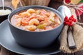 Soup with turkey, pasta, carrot, celery, tomato and cannellini beans, garnished with parmesan cheese, on the table with autumn