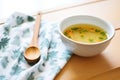 soup in a white bowl, wooden spoon, kitchen towel under bowl Royalty Free Stock Photo